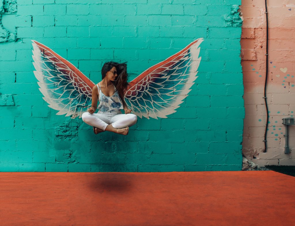 Femme avec des ailes d'ange dessiné sur un mur derrière