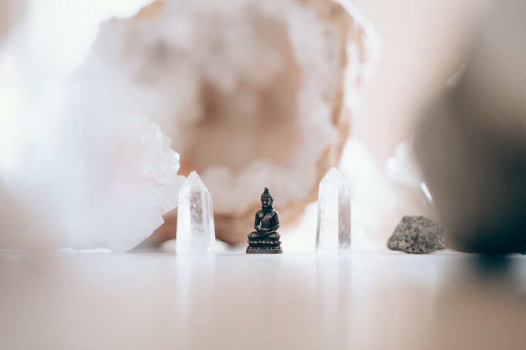 petite statue de bouddha dans un univers blanc