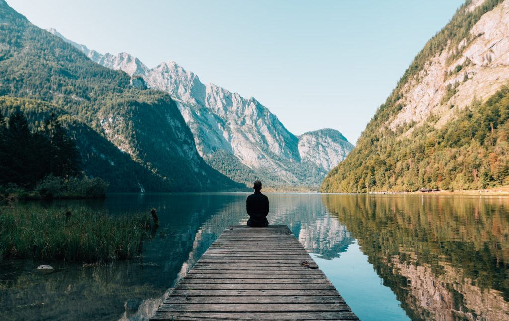 homme devant un lac regardant les montagnes