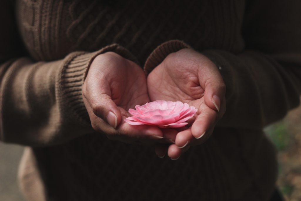 Femme tenant une rose dans sa main
