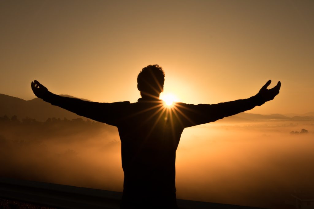 Homme devant le soleil couchant